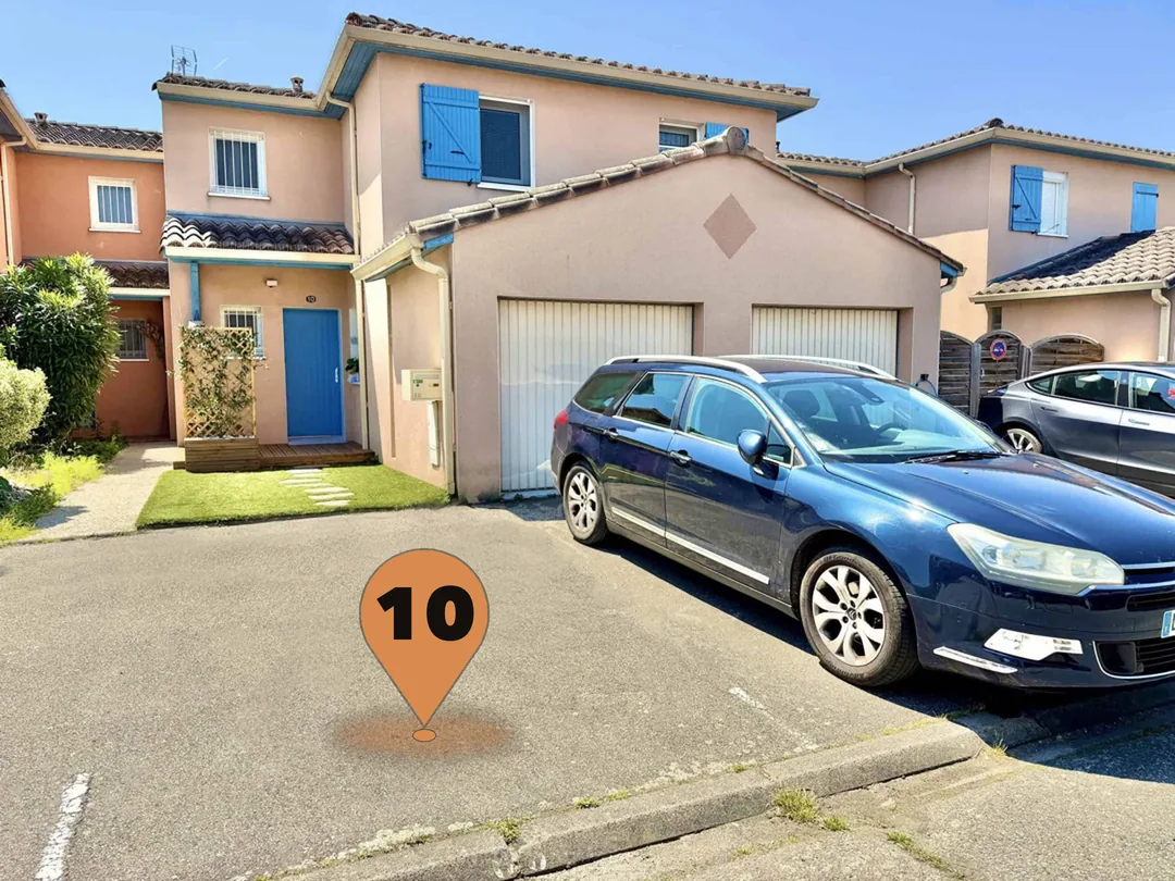 L'entrée du cabinet et, marquée d'un repère, la place de parking n° 10 réservée devant la maison